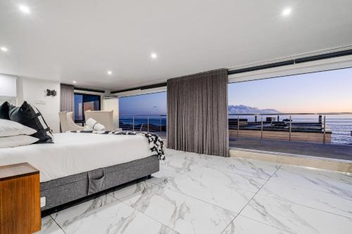 a bedroom with a large bed and a view of the ocean at The Lighthouse in Cape Town