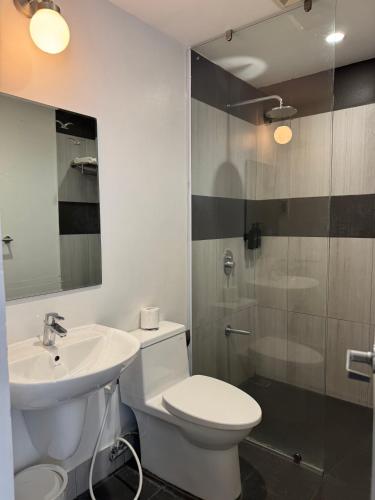 a bathroom with a toilet and a sink and a shower at LeBlanc Hotel in Antipolo