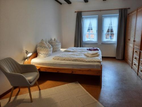 a bedroom with a bed with a chair and a window at Ferienhaus in Clenzer Schweiz in Clenze