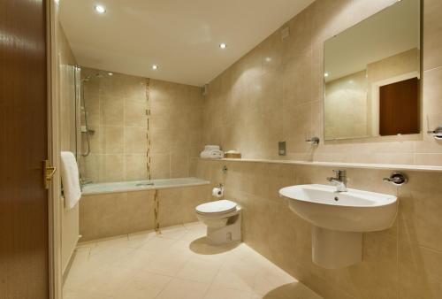 a bathroom with a sink and a toilet and a tub at The Stronlossit Inn in Fort William