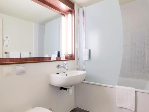 a bathroom with a sink and a toilet and a mirror at Campanile Saint-Malo ~ Saint-Jouan-Des-Guerets in Saint-Jouan-des-Guérets