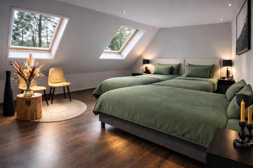 two beds in a bedroom with two windows at Groot vakantiehuis met sauna en bubbelbad in Diessen