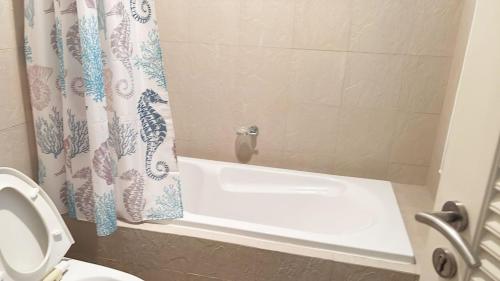 a bathroom with a white tub and a shower curtain at 1 BR Loft Condo in Cha-Am in Cha Am