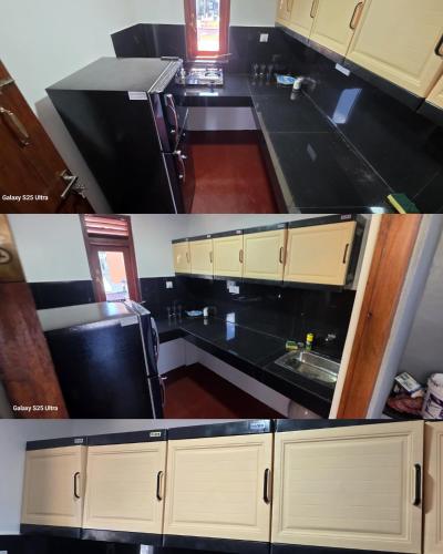 a kitchen with white cabinets and black counter tops at Aliya Stay in Galle