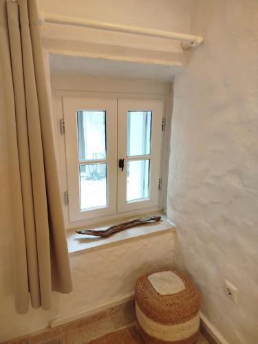 a window in a room with a stool in front of it at Casa del porto in Lákka