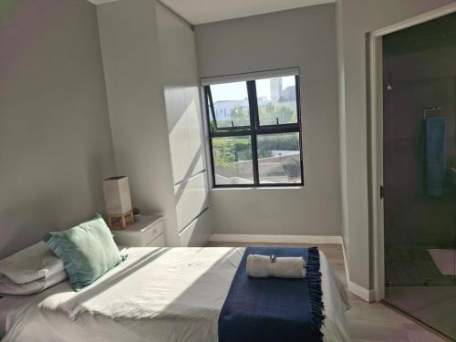a bedroom with a large bed with a window at SeeSkattie in St. Helena Bay