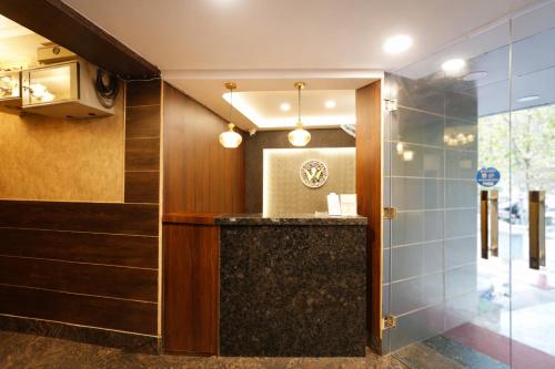 a lobby with a marble counter and a glass wall at Hotel Well Suites Koramangala in Bangalore