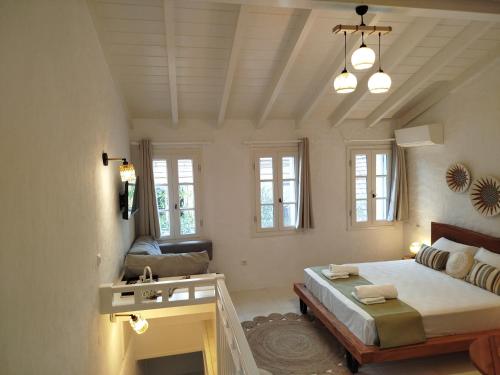 a bedroom with a bed and a couch and windows at Casa del porto in Lákka