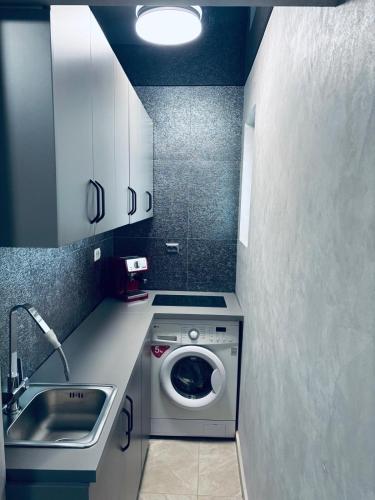 a small kitchen with a washing machine and a sink at BGD Residence in Galaţi