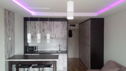 a kitchen with a bar with a purple lighting at Apartments Vanja i Vrh in Kopaonik