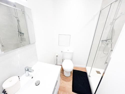 a white bathroom with a toilet and a shower at L'Orchidée Marine, T2, 100m plage et du commando in Saint-Nazaire