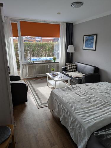 a bedroom with a bed and a living room at Appartementhaus Martel - Adults Only in Travemünde