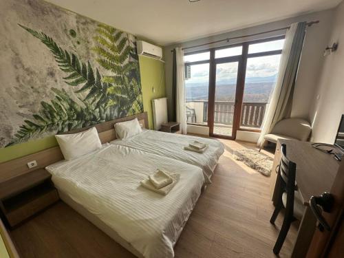 a bedroom with a bed and a large window at Хотел Магура in Rabisha