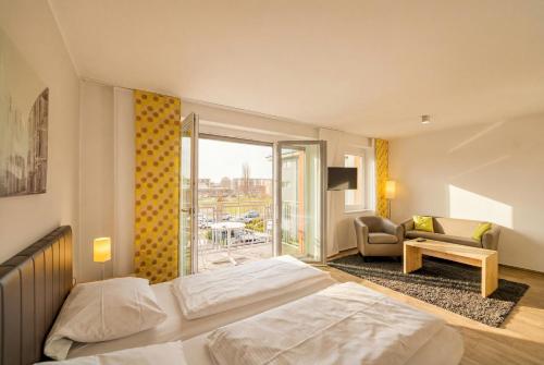 a hotel room with a bed and a balcony at ADAPT APARTMENT HOTEL BERLIN - Adlershof in Berlin