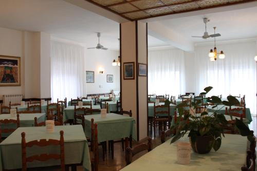 un comedor con mesas verdes y sillas en Hotel 2 Mari - Vieste, en Vieste