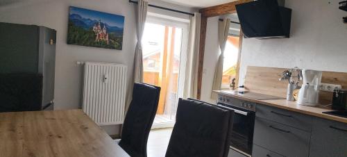 a kitchen with a table and chairs and a window at FeWo-Hacke in Halblech