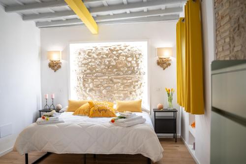 a bedroom with a large bed with yellow pillows at Casa Rachele alloggio turistico in Sabina in Poggio Mirteto