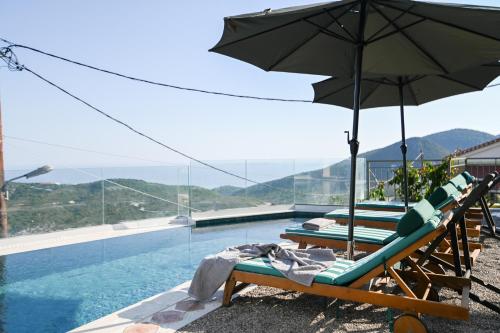 a group of chairs with an umbrella next to a swimming pool at Tepeleni, Parga Apts with Pool in Agiá