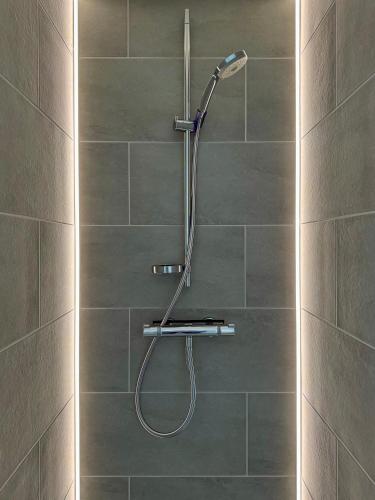 a shower with a shower head in a bathroom at Nije Haven Bed & Breakfast in Wrixum