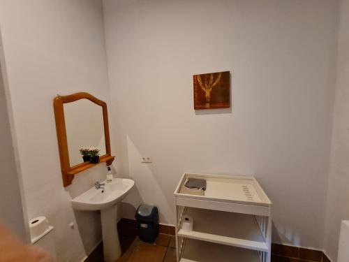 a white bathroom with a sink and a mirror at Casa OASIS in Almonte