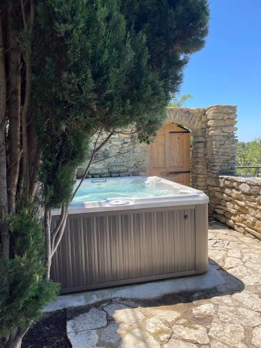 a hot tub in a garden with a tree at La maison Haut-perché townhouse with view and jacuzzi in Saumane-de-Vaucluse