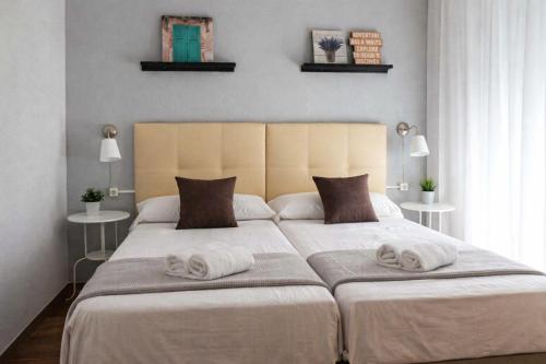 a bedroom with a large bed with towels on it at APN Hatabin in Granada