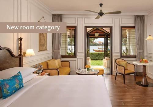 a bedroom with a bed and a living room at Anantara Hoi An Resort in Hoi An