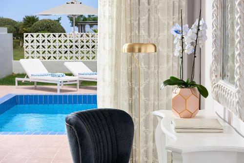 a desk and a chair next to a pool at Mythos Palace Resort & Spa in Georgioupolis