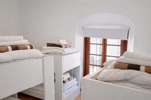a room with white shelves with towels and a window at Pórtico del Azahín in Cazalla de la Sierra