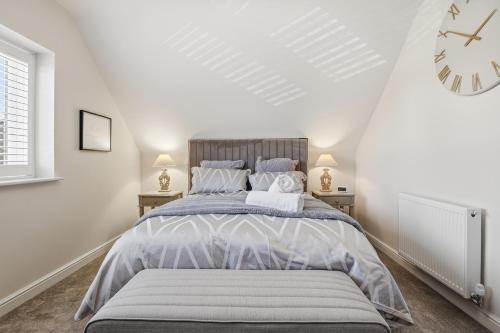 a bedroom with a bed and a clock on the wall at The Luxe Pool House, Westoning in Westoning