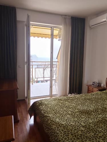 a bedroom with a bed and a window with a balcony at Alegria in Varna City