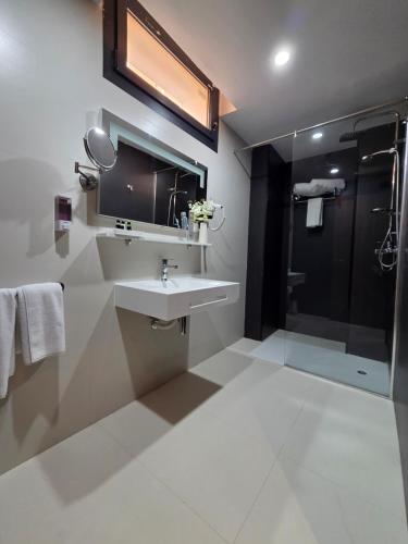 a bathroom with a sink and a shower at El Aziz Inn in Cheraga