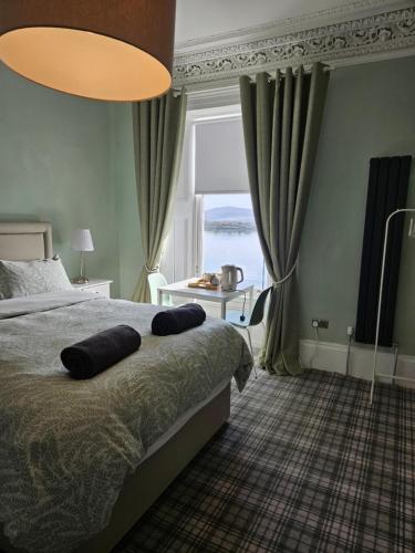 a bedroom with a bed and a large window at The Old Bank bed & breakfast in Millport