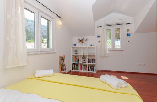 a bedroom with a large yellow bed and windows at Holiday House Therapy in Omiš