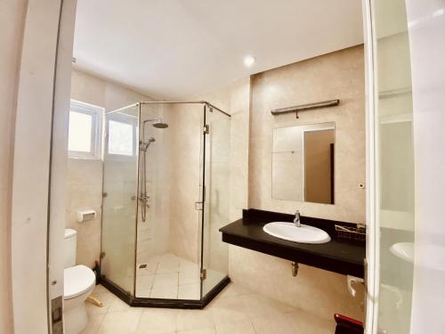 a bathroom with a shower and a sink and a toilet at RosePark Tuan Chau in Ha Long
