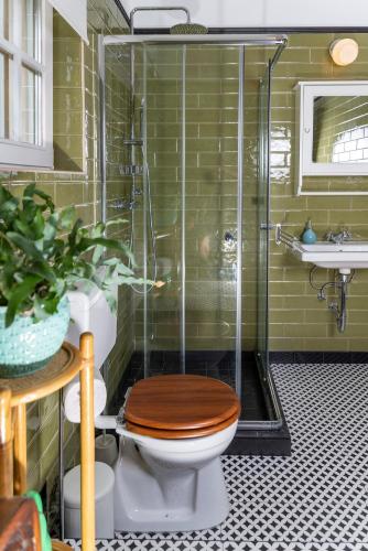 a bathroom with a toilet with a glass shower at KIS CINKE Guesthouse in Tahitótfalu