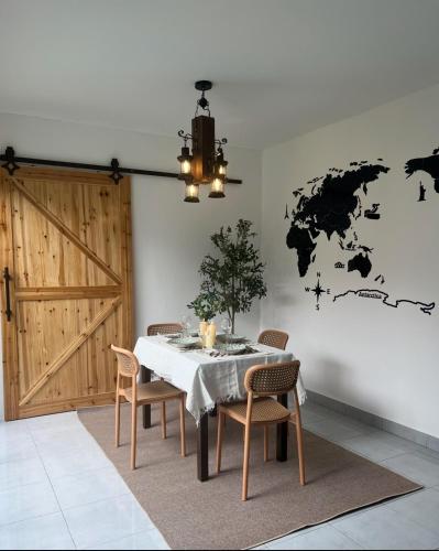 a dining room with a table and a world map on the wall at Duchess Home Taman Colonial in Raub