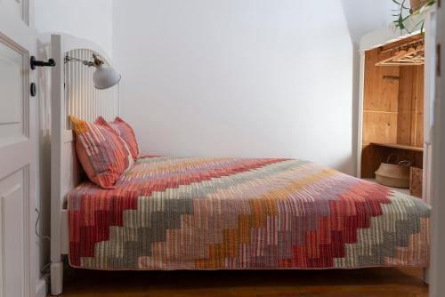 a bedroom with a bed with a colorful blanket at KIS CINKE Guesthouse in Tahitótfalu