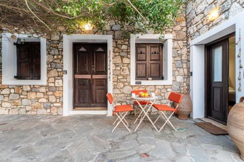 a table and chairs in front of a stone house at Infinity III - Tranquil Studio Retreat in Kos in Lagoúdi Zía