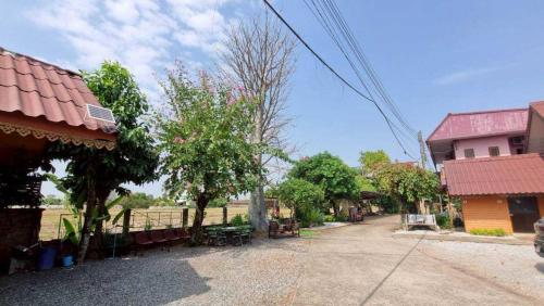 an empty street in a village with houses and trees at Sinsawat Resort in Uttaradit