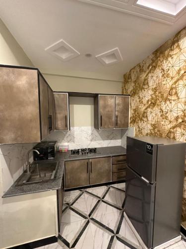 a kitchen with a sink and a refrigerator at Two Bed Appartment in Islamabad
