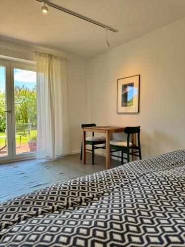 a bedroom with a bed and a desk and a window at Nije Haven Bed & Breakfast in Wrixum