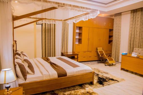 a bedroom with a bed and a room with a desk at Lucerna Kabgayi Hotel 