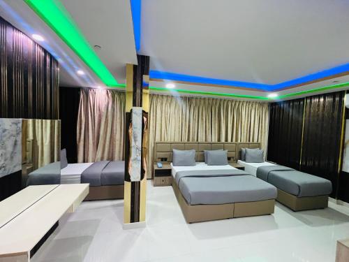 a hotel room with two beds and a couch at Town Plaza Hotel Apartments Ras Al Khaimah in Ras al Khaimah