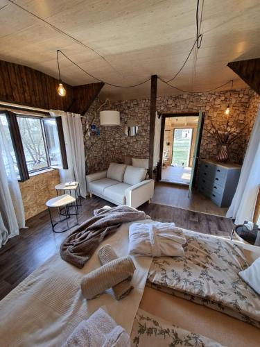 a bedroom with a large bed and a couch at Chatka U Vlka in Lnáře