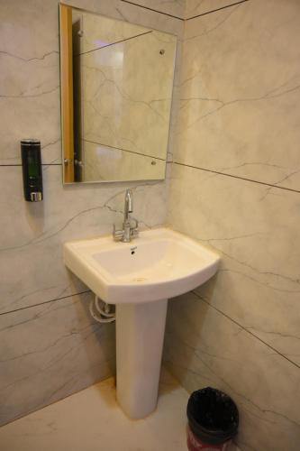 a bathroom with a sink and a mirror at SHIVAAY GARDEN in Kannauj