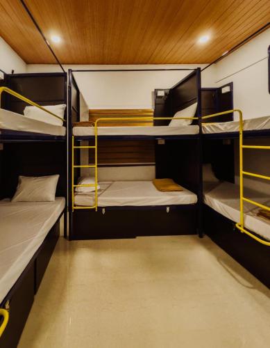 a room with three bunk beds on a boat at Ostello in Varkala