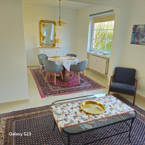 a living room with a table and chairs and a mirror at Ganze Wohnung mit Garten in Bremen