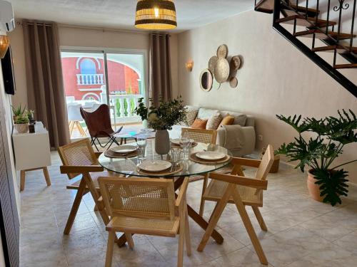 a living room with a glass table and chairs at Casa Verde 56 in Cumbre del Sol