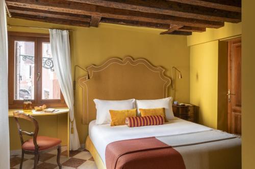 a bedroom with a bed and a chair and a window at Hotel Riva in Venice